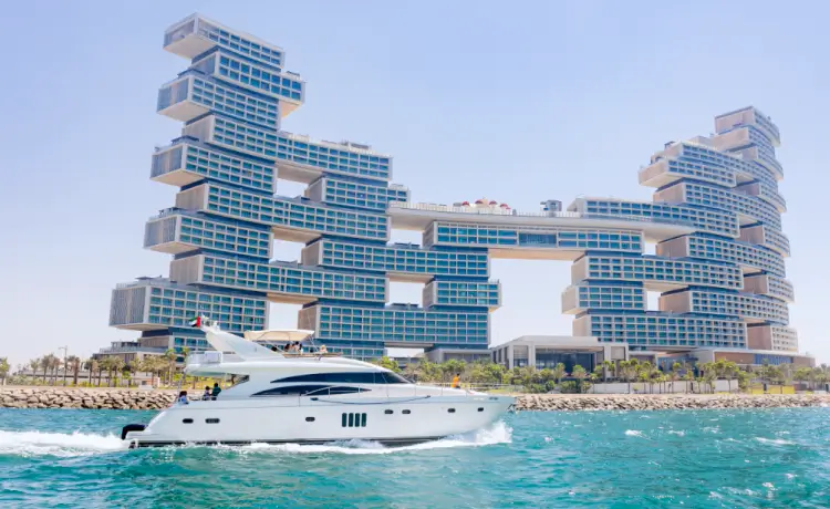 A luxury yacht full of tourists cruising past the waters near Atlantis The Royal in Dubai